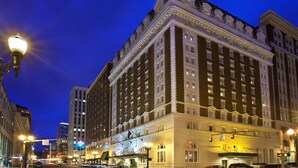 Un grand hôtel historique, doté de nombreux étages, d’une entrée imposante et d’une façade bien éclairée.