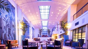 A spacious lobby with a high ceiling, large windows, and modern seating arrangements. - Hotel Theodore Seattle Downtown, Tapestry by Hilton (Seattle)