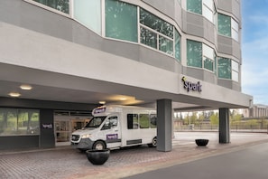 A building with a 'spark' sign, a white van parked in front, and a paved entrance area.