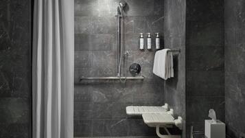 A modern bathroom with a walk-in shower, a bench, and a towel rack.