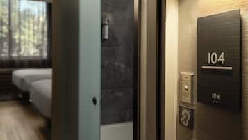 Habitación de hotel con cama, baño con espejo y una placa con el número 104.