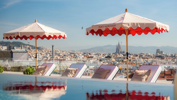 A rooftop pool with lounge chairs and umbrellas, offering a city view. - InterContinental Barcelona by IHG (Barcelona)