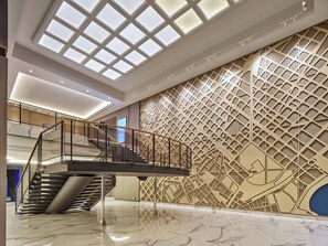 A modern interior with a central staircase, a geometric patterned wall, and a skylight. - InterContinental Barcelona by IHG (Barcelona)