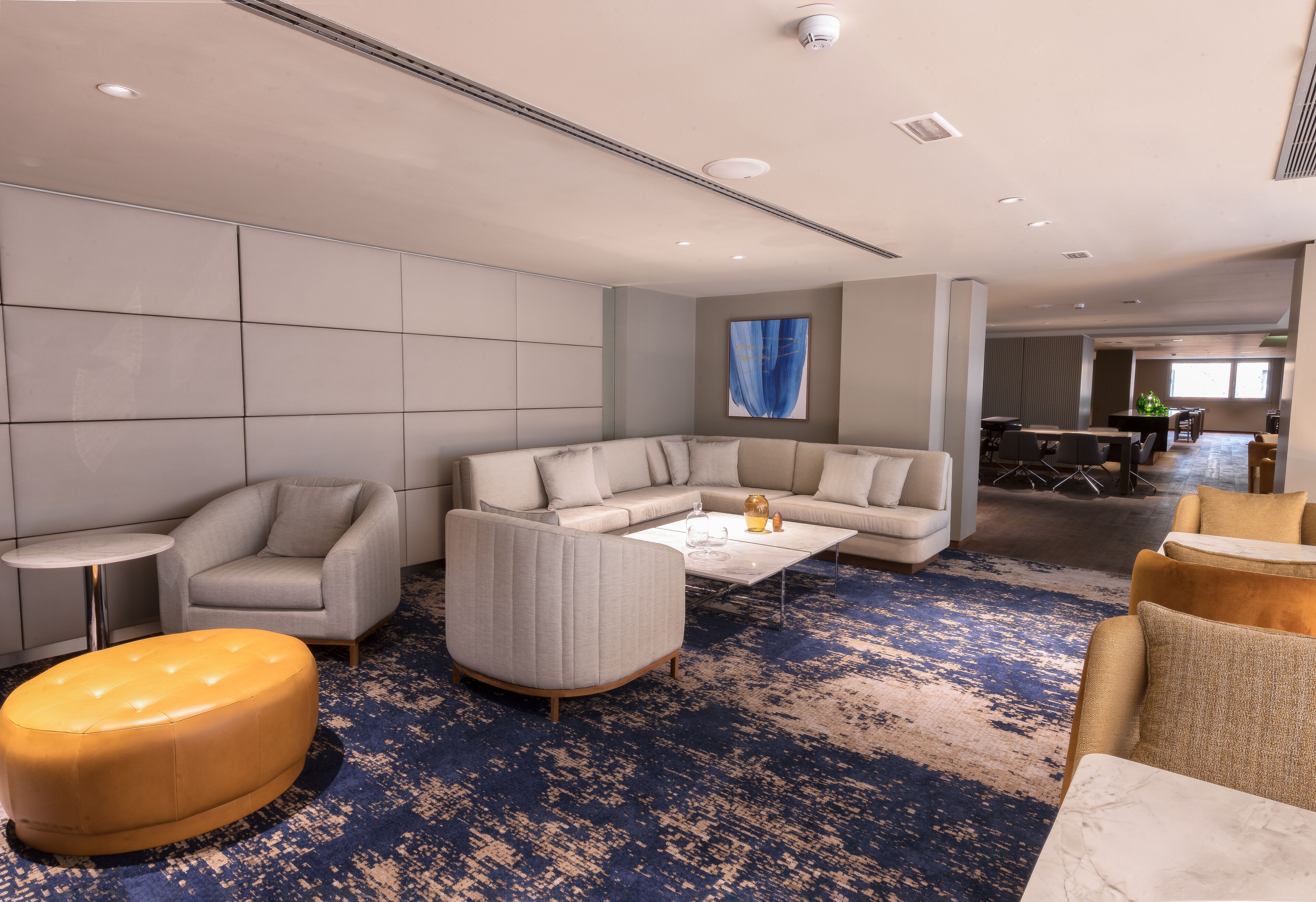 A modern living room with a sectional sofa, a round ottoman, and a coffee table.