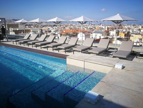 Piscine extérieure en saison, chaises longues