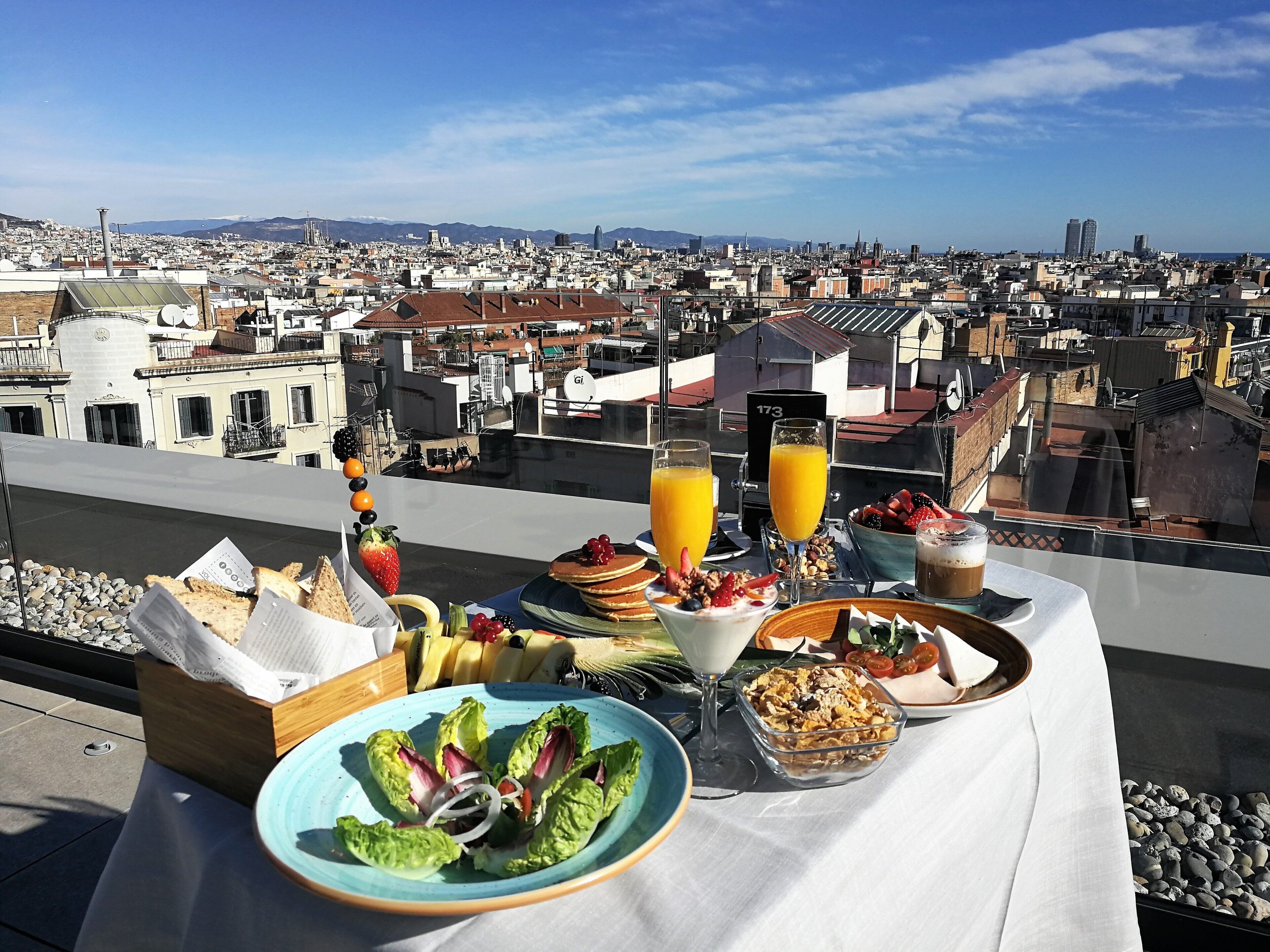 A table with breakfast items and a city view.