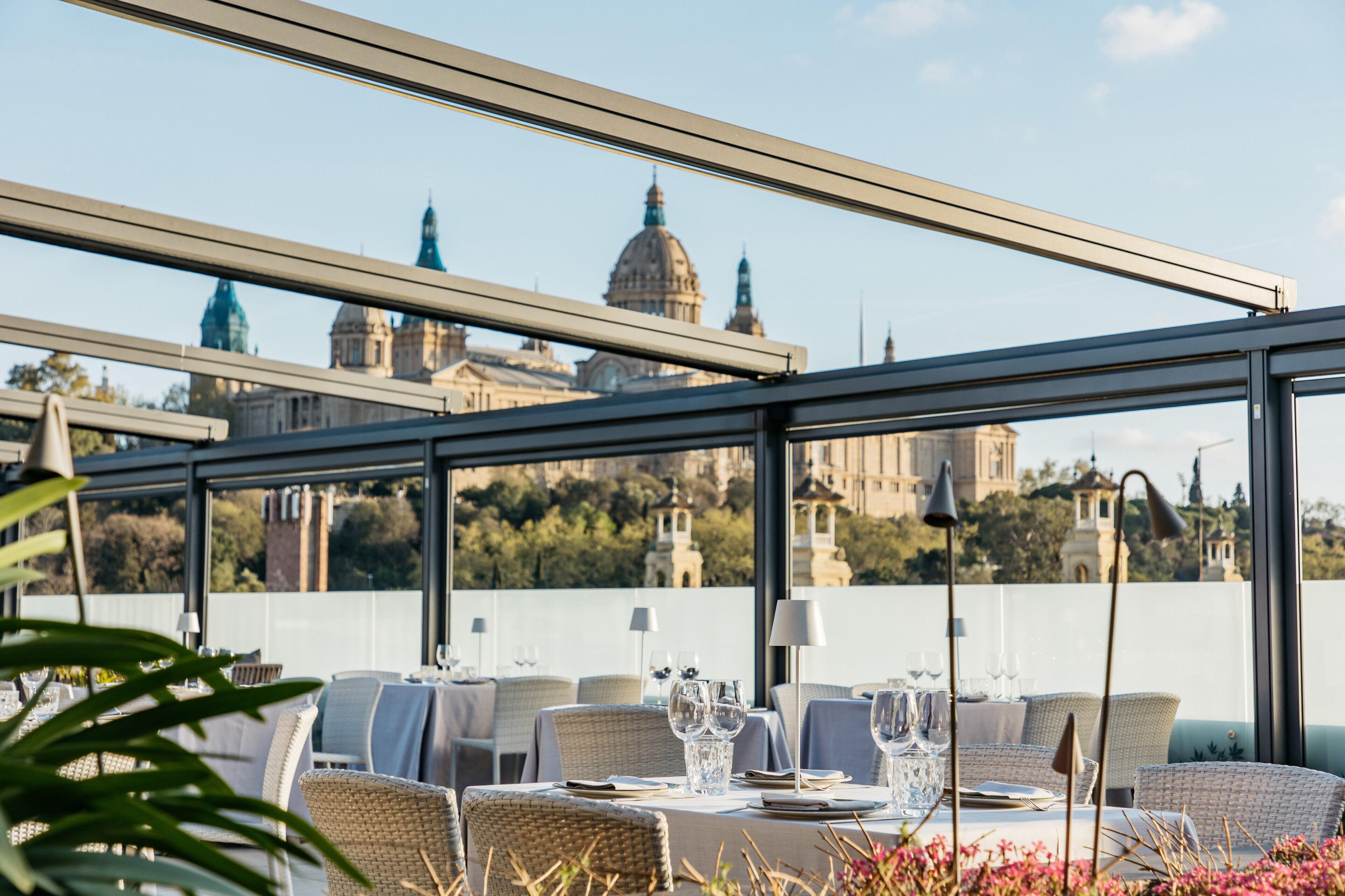 A restaurant with tables set for dining, overlooking a historic building with domes.