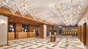 A spacious lobby with a marble floor, a reception desk, and a bar area. - InterContinental Barcelona by IHG (Barcelona)