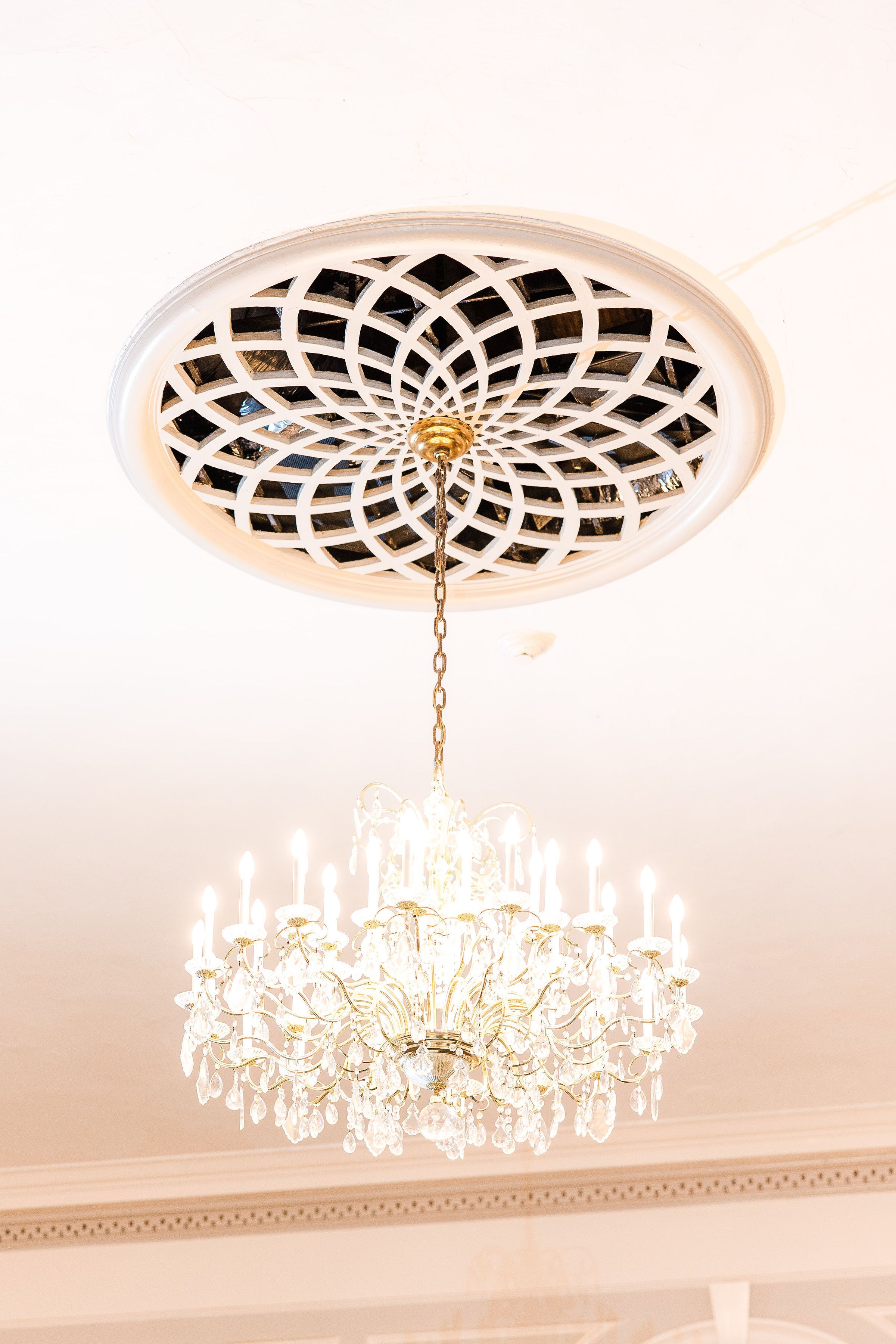 A chandelier with a geometric ceiling design.