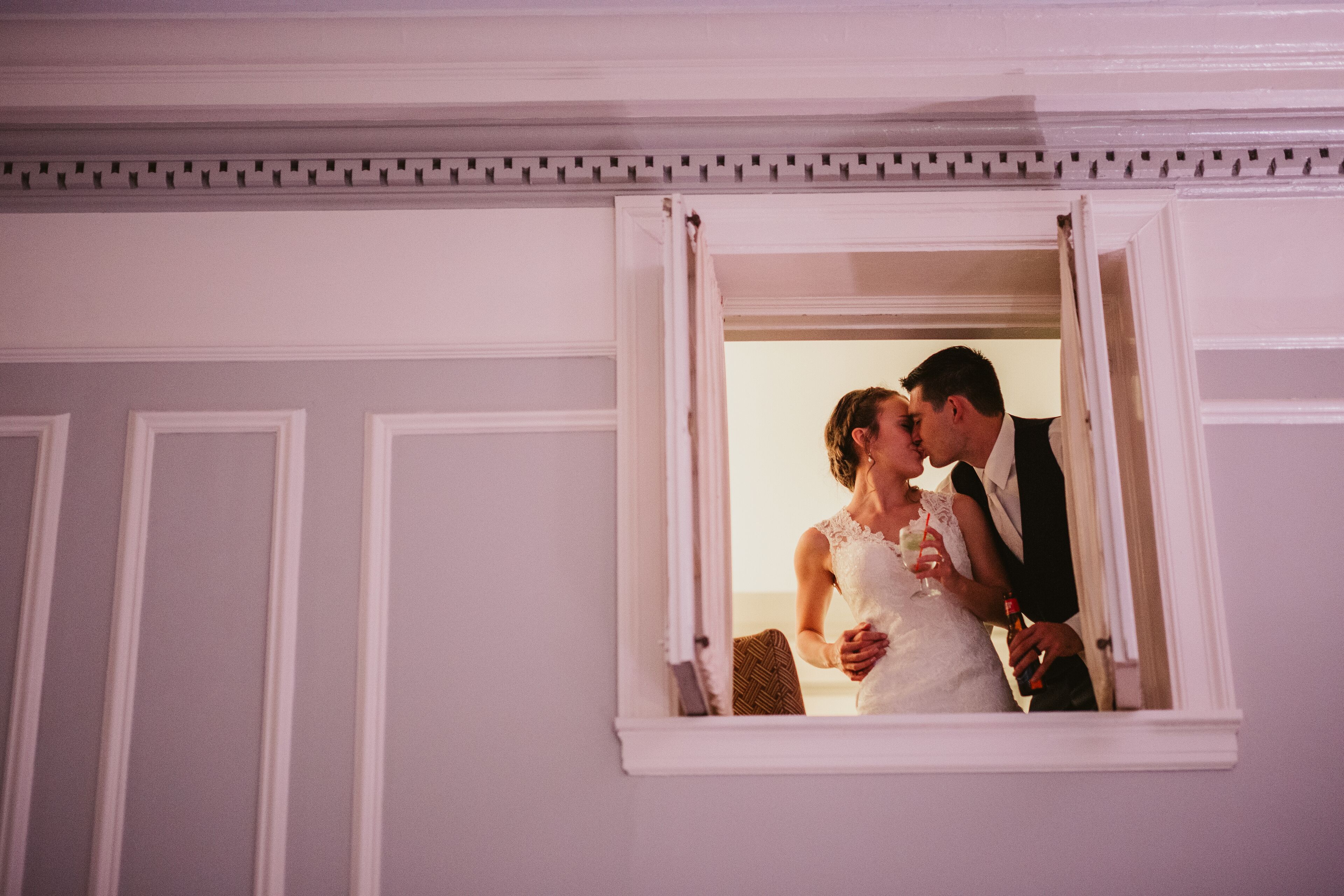 Una pareja besándose a través de una ventana con un techo decorativo.
