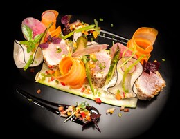 Diversos alimentos dispuestos artísticamente sobre un plato negro.