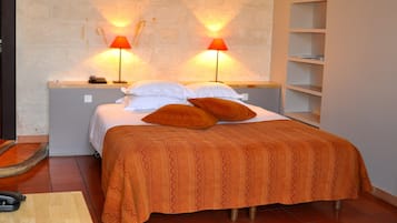 Een slaapkamer met een bed, twee bedlampen, een bedtelefoon en een nachtkastje van hout.