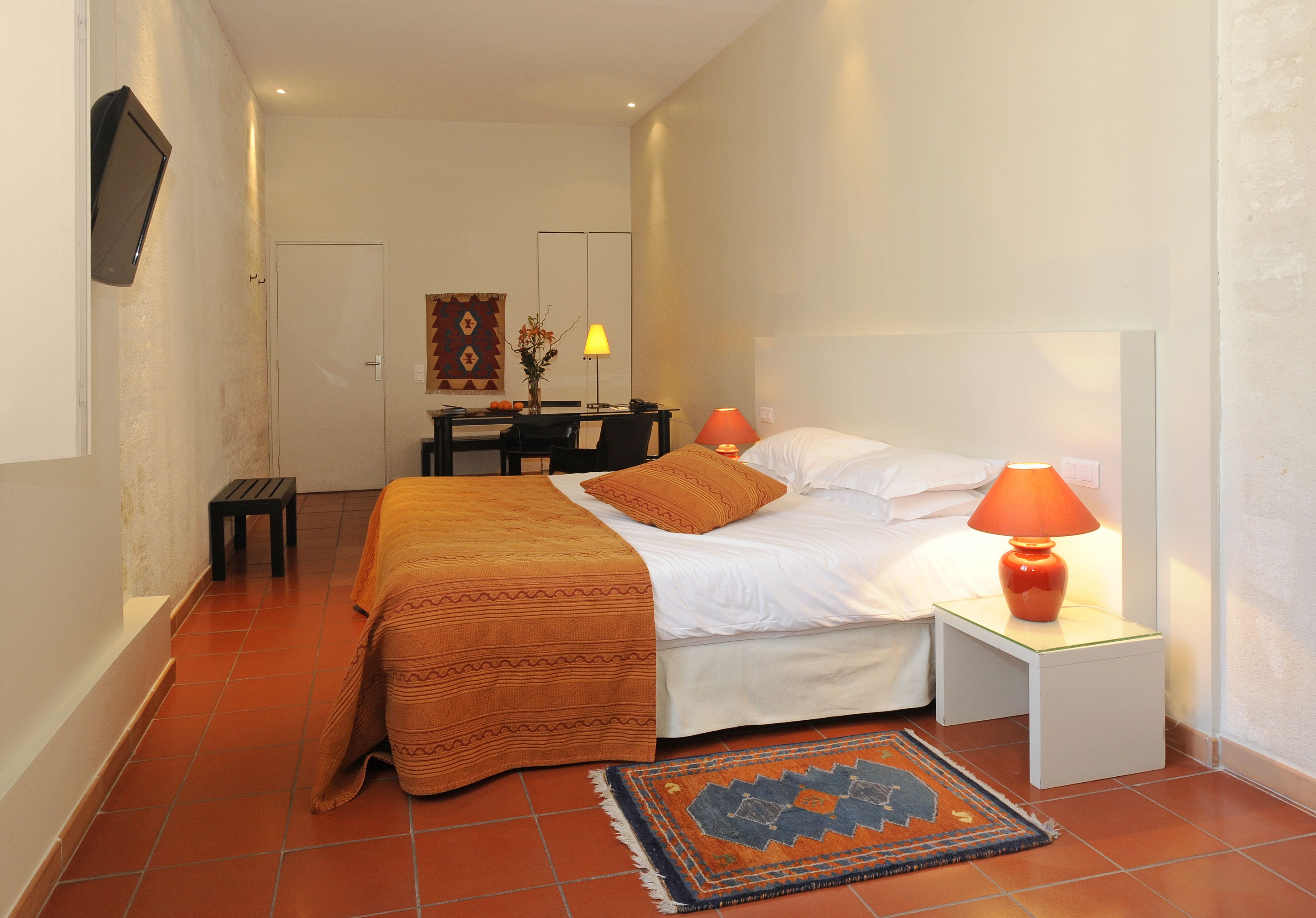 Una habitación de hotel con cama, mesitas de noche, escritorio y silla.