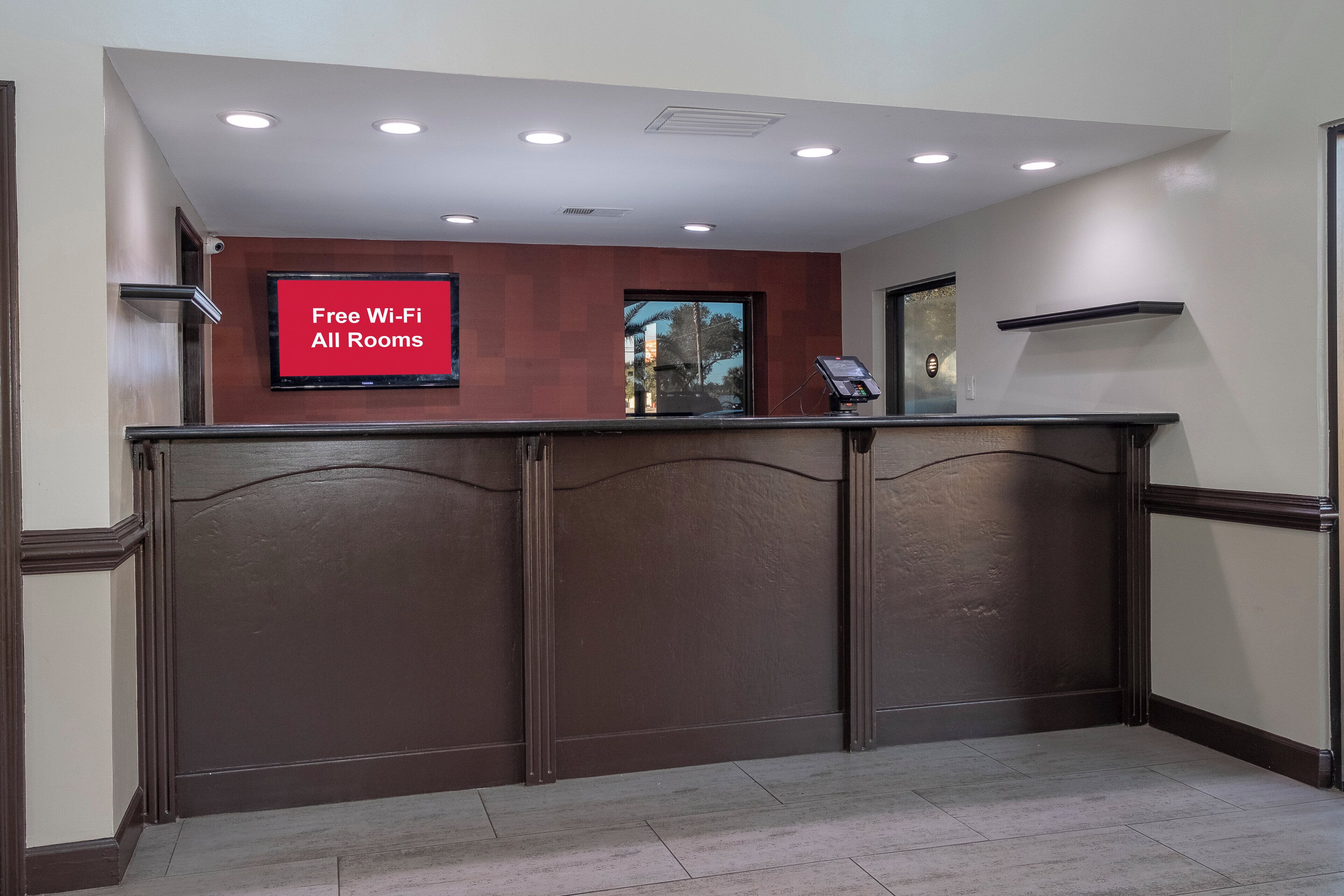 A reception desk with a sign indicating free Wi-Fi in all rooms.