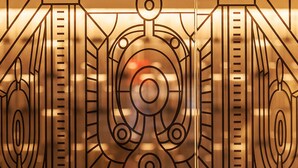 A decorative metal gate with geometric patterns and a central circular design. - The Hotel @ Fifth Avenue (New York)