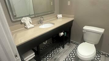 A bathroom with a sink, mirror, and toilet.