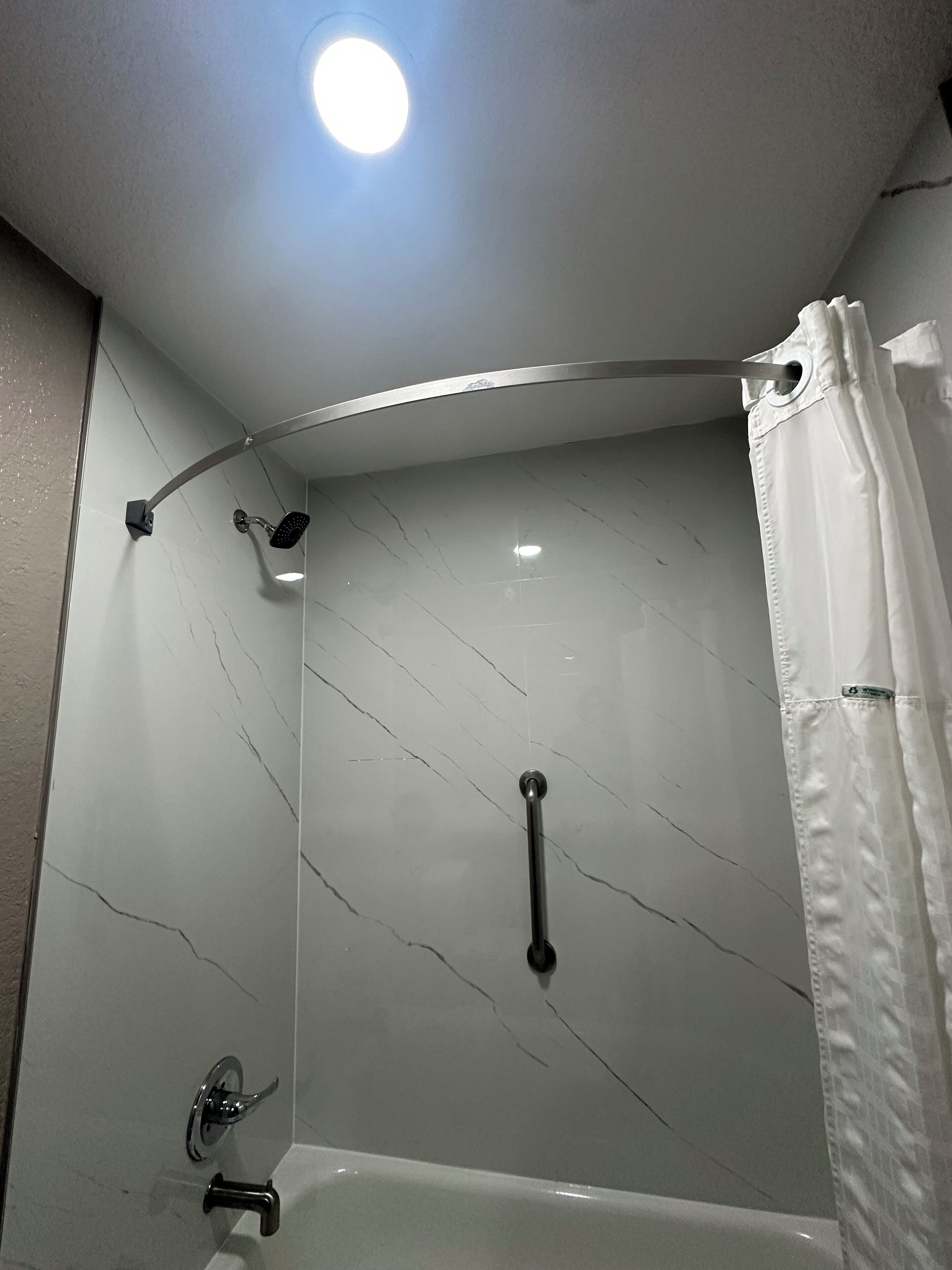 Un baño moderno con ducha, bañera y retrete.