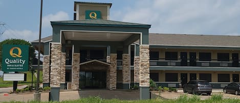 Un hôtel doté d’une façade en pierre, d’une entrée couverte et d’une enseigne indiquant qu’il fait partie de la chaîne Quality Inn & Suites de Choice Hotels.