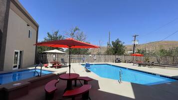 Een seizoensgebonden buitenzwembad en parasols bij het zwembad