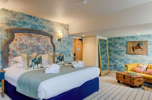 A bedroom with a large bed, a wooden dresser, a sofa, and a mirror. - The George of Colchester (Colchester)