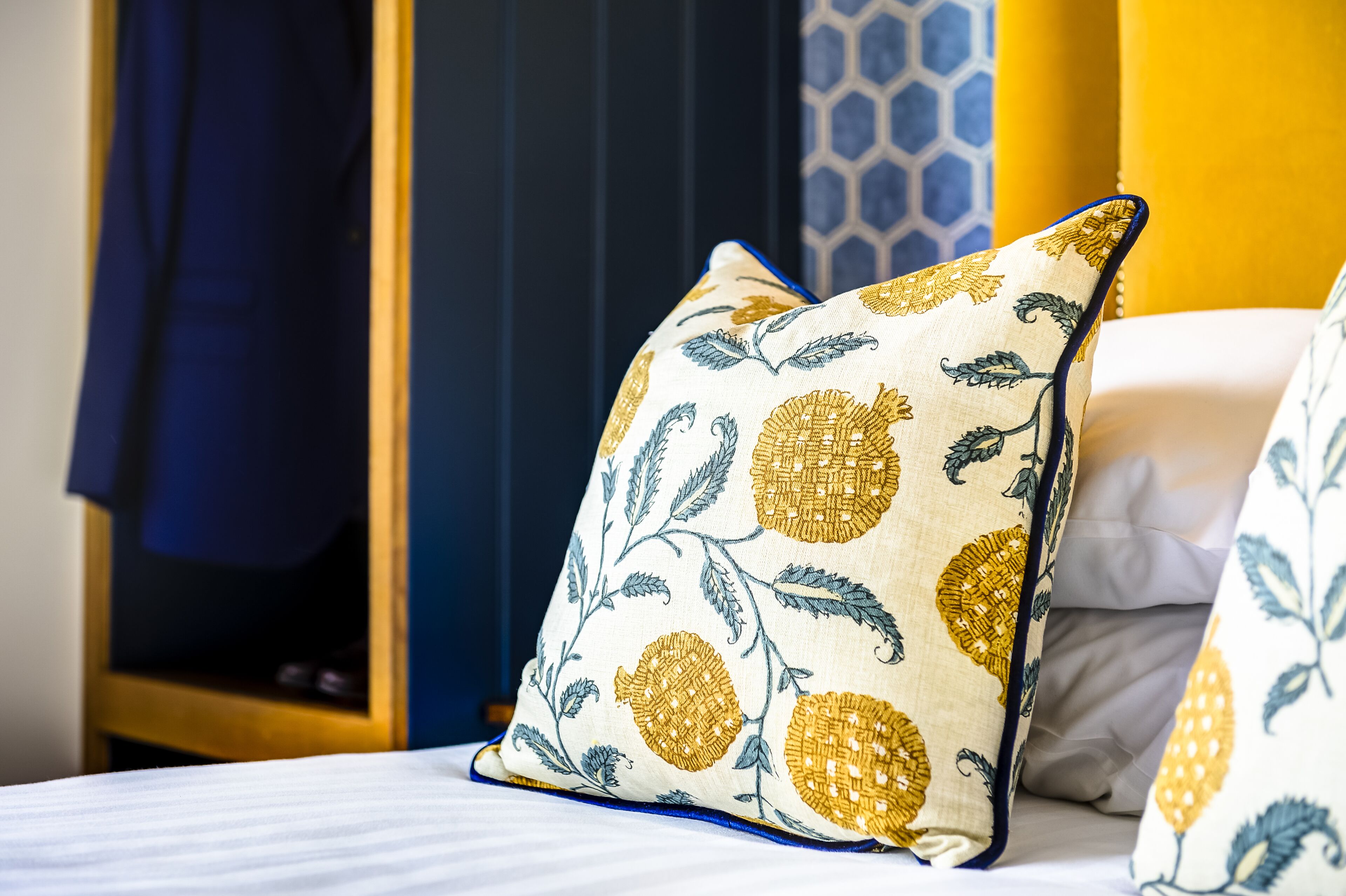 A bed with pillows featuring a floral pattern.