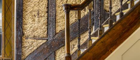 Una escalera de madera con una pared texturizada al fondo.