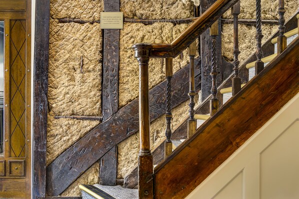 Un escalier en bois, avec un mur à texture en arrière-plan.