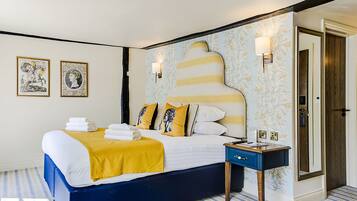 A bedroom with a bed, bedside table, and a mirror.