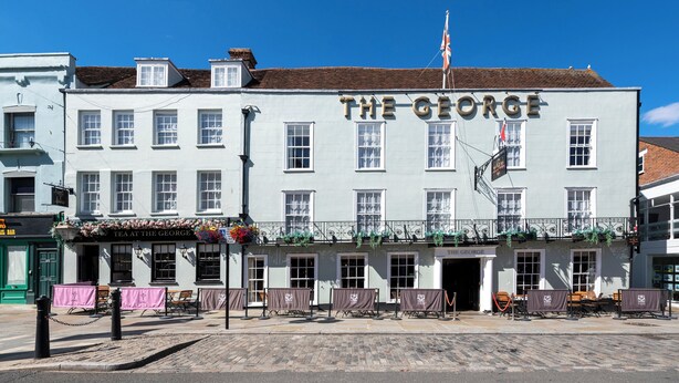 A building with a sign reading "The George" and a flag on top.