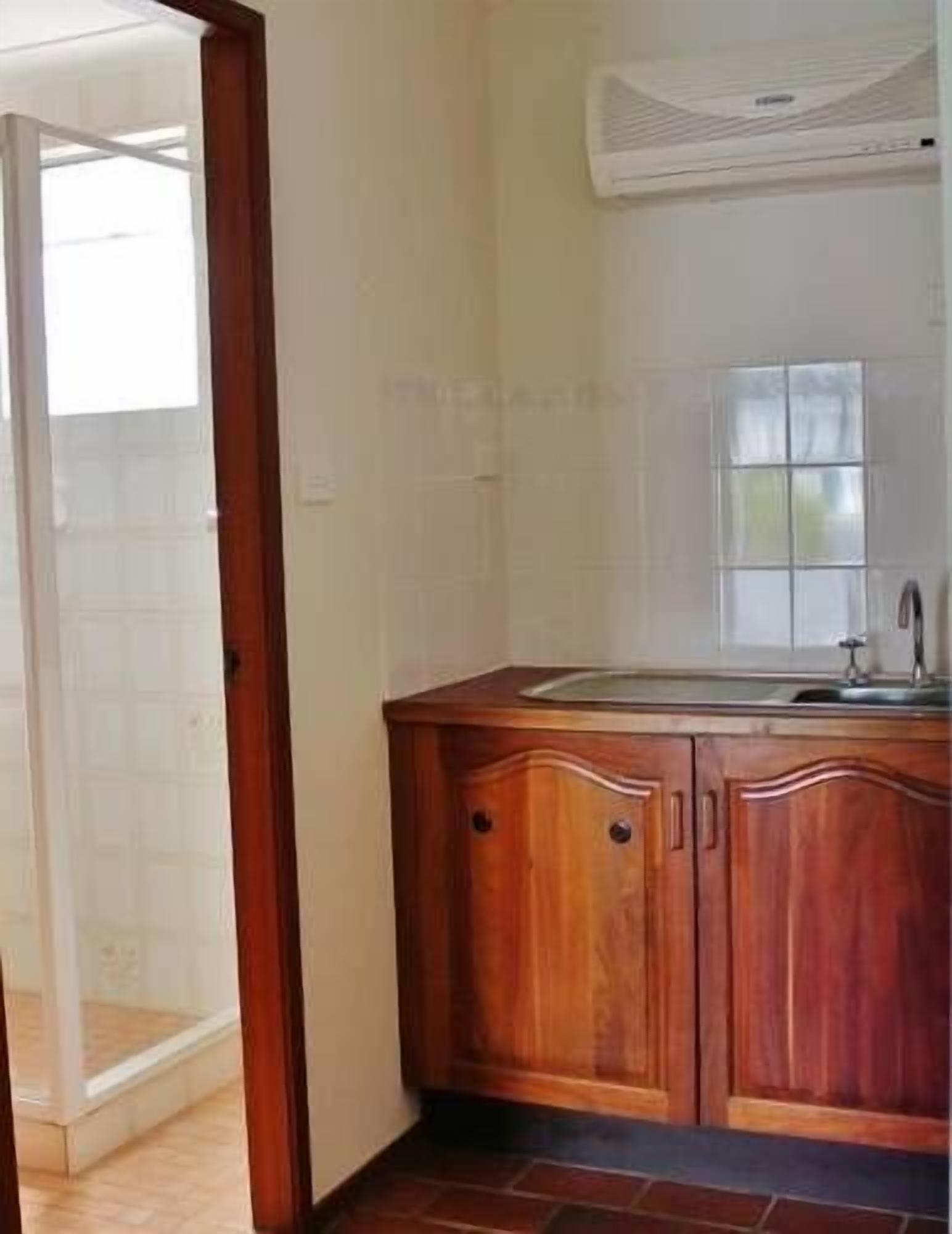 A kitchen with wooden cabinets, a sink, and a window.