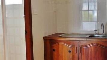 A kitchen with wooden cabinets, a sink, and a window.
