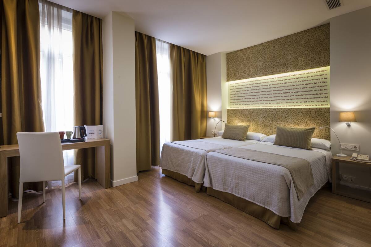 Una habitación de hotel con dos camas, un escritorio y una silla.