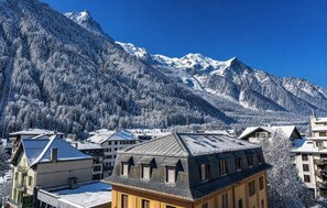 A mountain town with snow-covered buildings and a clear blue sky. - Hôtel Le Morgane (Chamonix-Mont-Blanc)