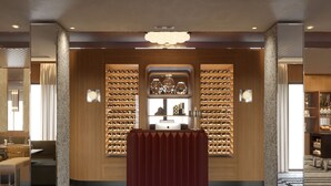 Un hall de hotel con una bodega de vinos, una recepción y una zona de estar.