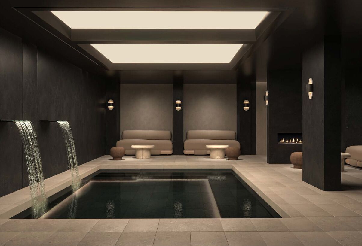 Un espace spa moderne doté d’une piscine rectangulaire, de deux coins salon et d’une cheminée.
