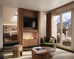 A modern hotel room with a fireplace, a green armchair, a coffee table, and a view of mountains through large windows. - Hôtel Le Morgane (Chamonix-Mont-Blanc)