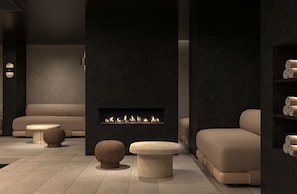 A modern interior with a fireplace, sofas, and a small table. - Hôtel Le Morgane (Chamonix-Mont-Blanc)