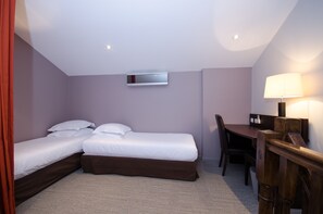Cozy retreat with a single bed, desk, and chair, perfect for a quiet workspace or dining area.