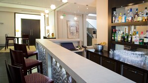 Un espace bar avec un comptoir, des sièges et un assortiment de bouteilles.