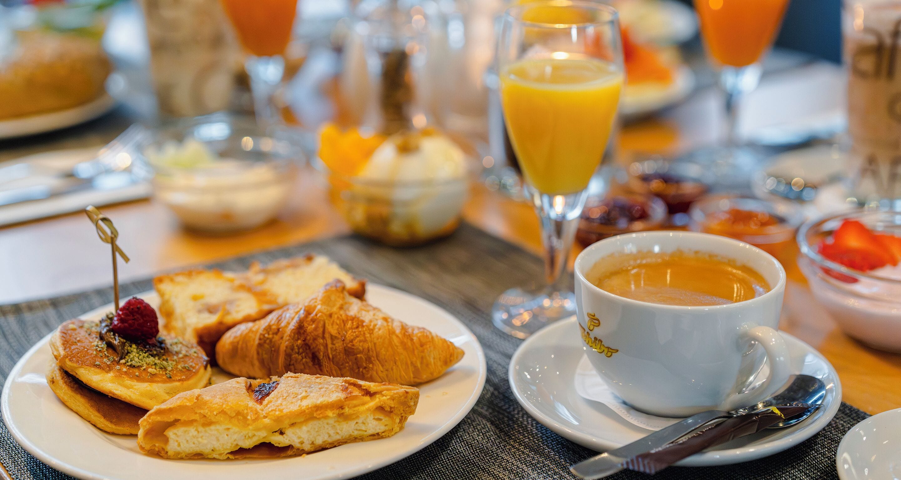 Desayuno con cruasanes, tortitas y una taza de café.