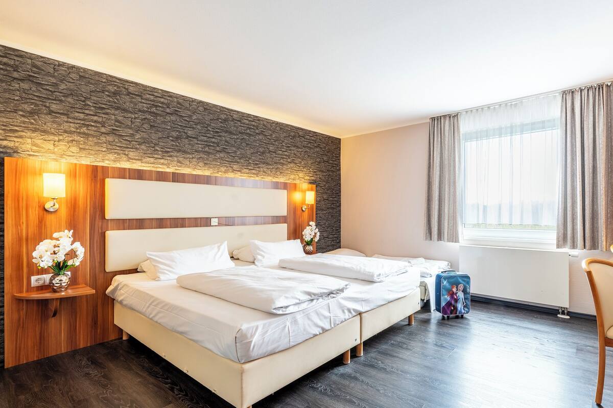 Una habitación de hotel con una cama grande, un escritorio y una silla.