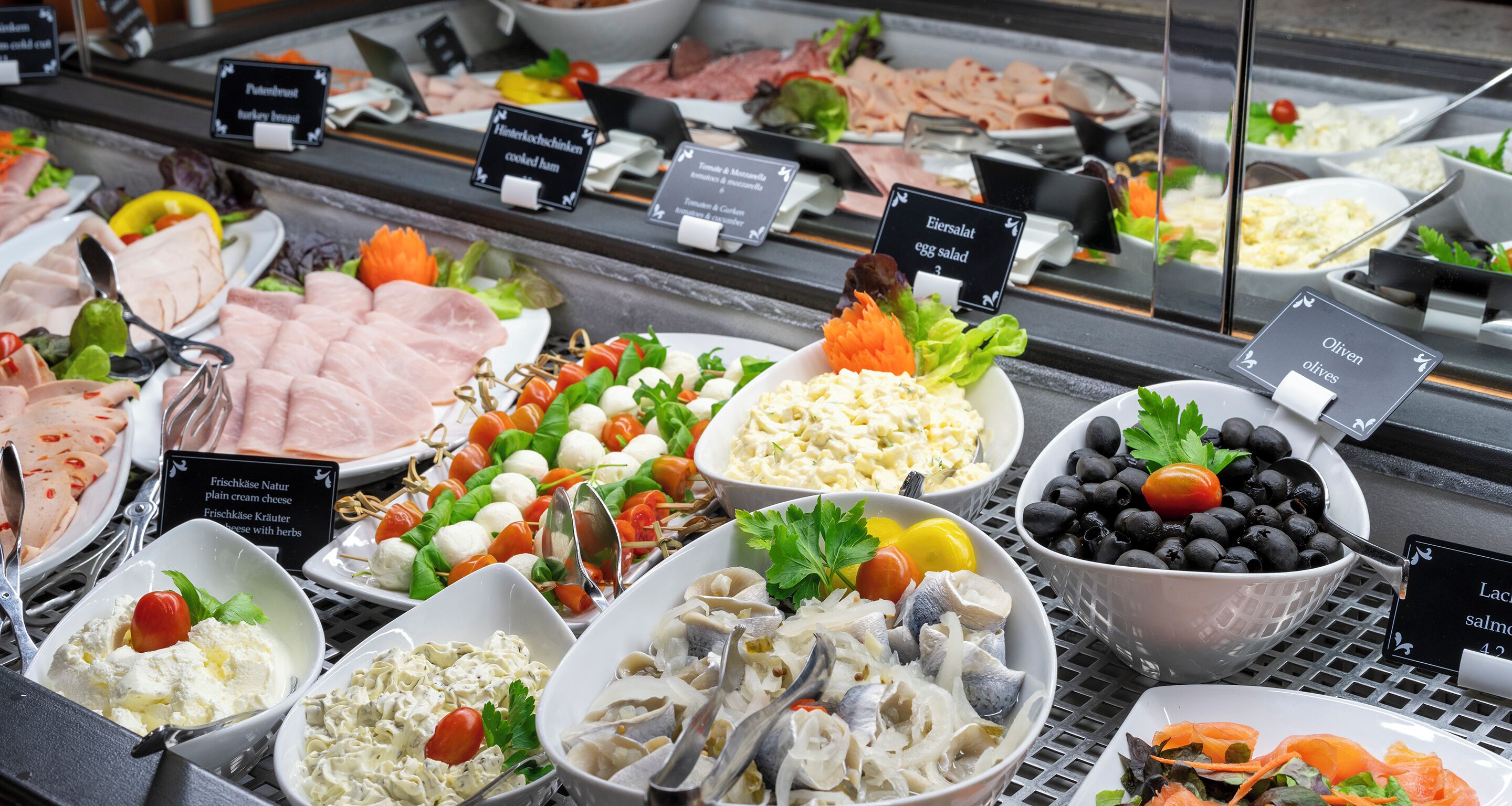 A buffet with various dishes including salads, seafood, and meats.