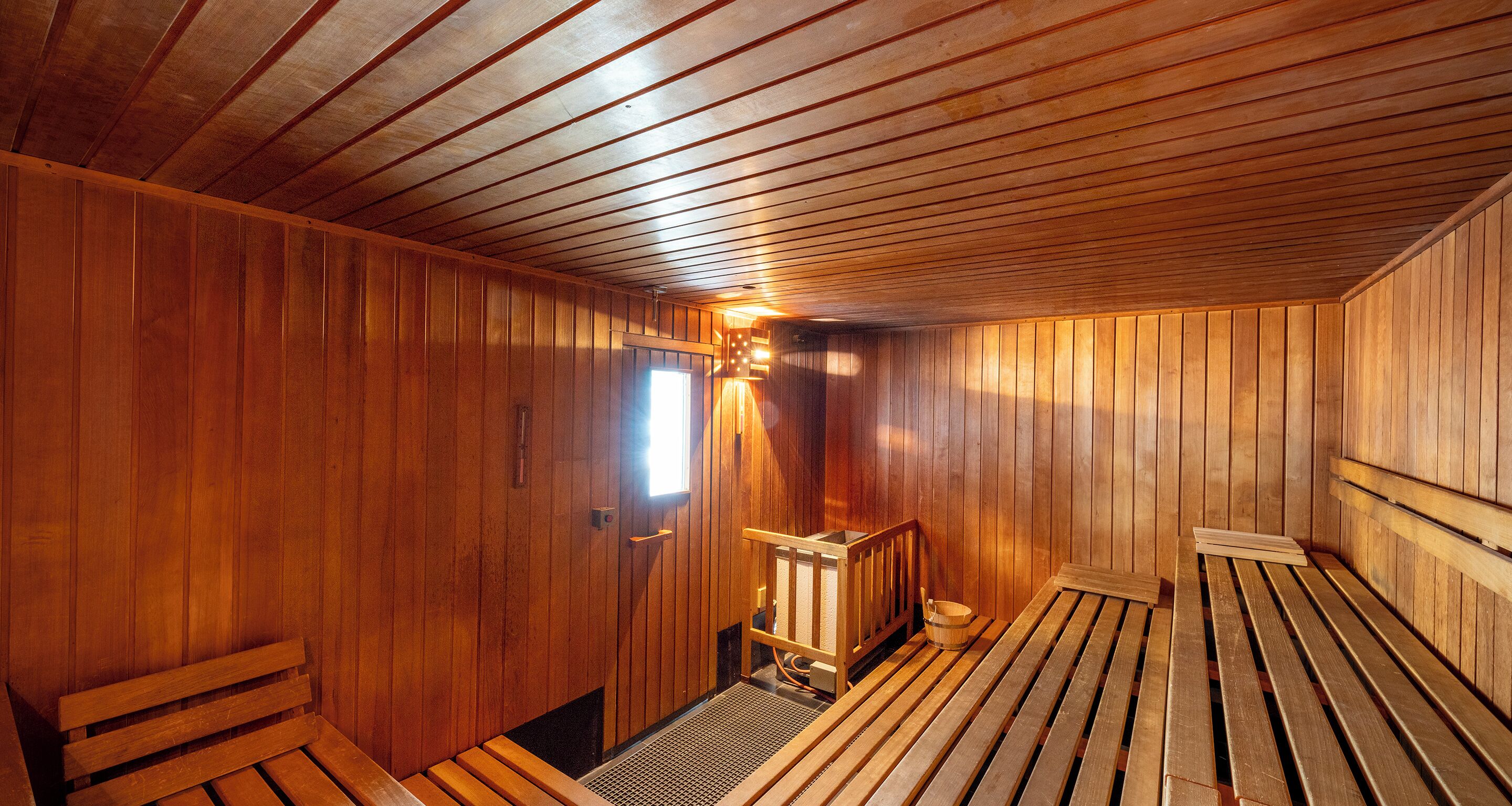 A sauna room with wooden walls and benches.