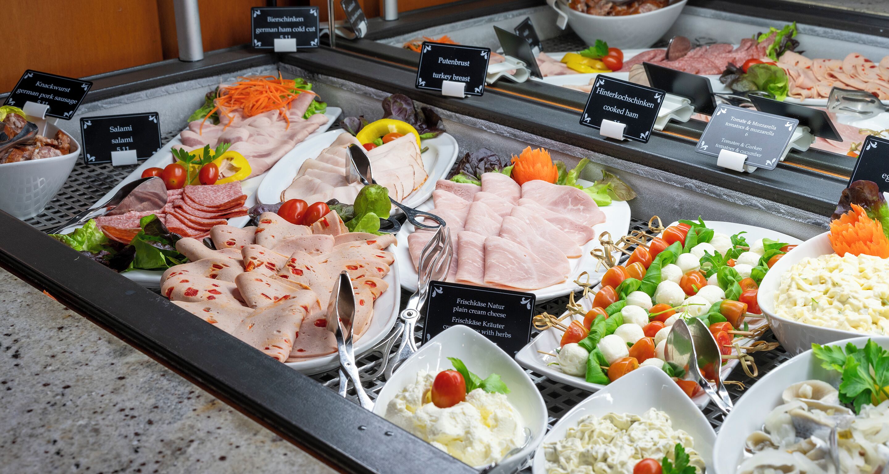 Un buffet proposant une variété de charcuteries, de fromages et de salades.
