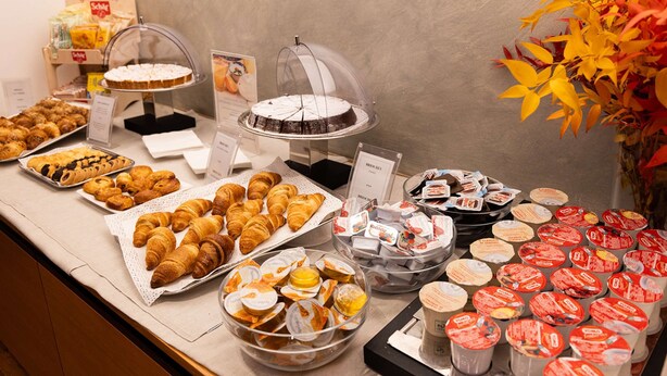 A buffet with various pastries, cakes, and packaged snacks. - Best Western Hotel Major (Milan)