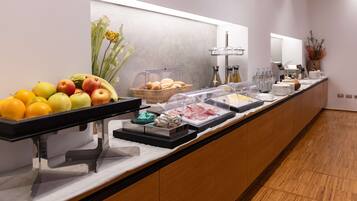 Un buffet con frutta, pane e diversi cibi.
