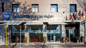 The exterior of Best Western Hotel Major with a modern facade, large windows, and multiple flags. - Best Western Hotel Major (Milan)