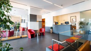 A modern hotel lobby with red seating, a reception desk, and a glass railing. - Best Western Hotel Major (Milan)