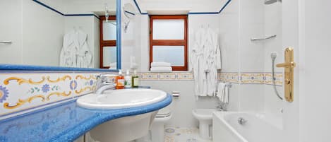 A bathroom with a large sink, a toilet, a bidet, and a bathtub.