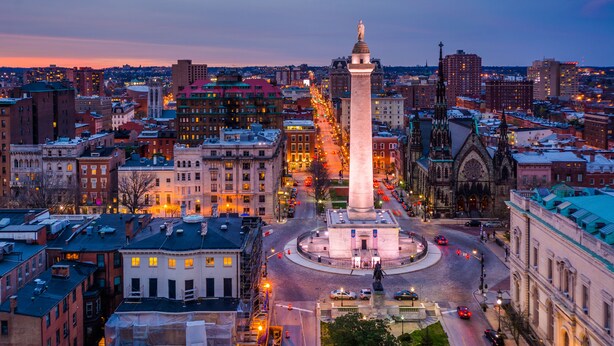 A cityscape with a prominent monument at a roundabout, surrounded by buildings and streets. - Hotel Revival Baltimore (Baltimore)